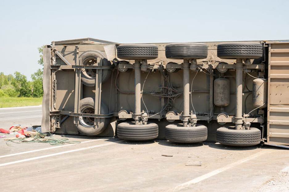 A truck is on its side in an accident. The image details the mechanics underneath the truck.